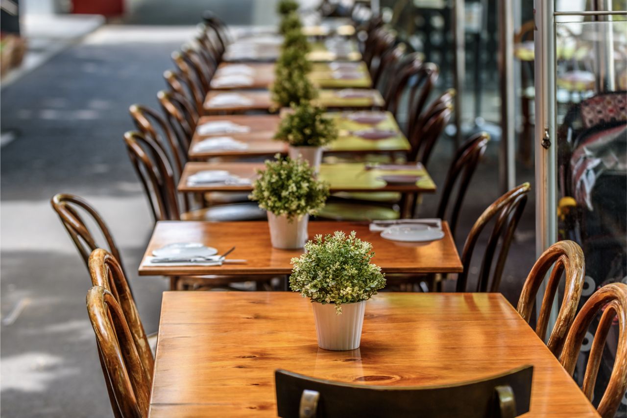 A row of chairs and tables at a outdoor cafe